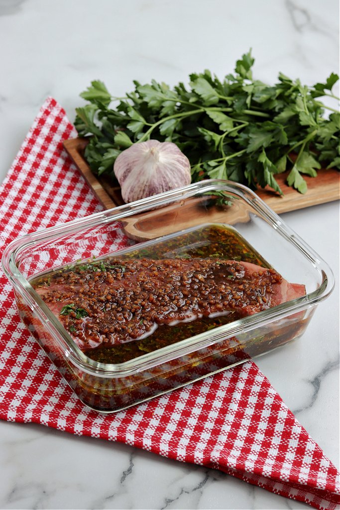 Steak marinant dans un plat en verre