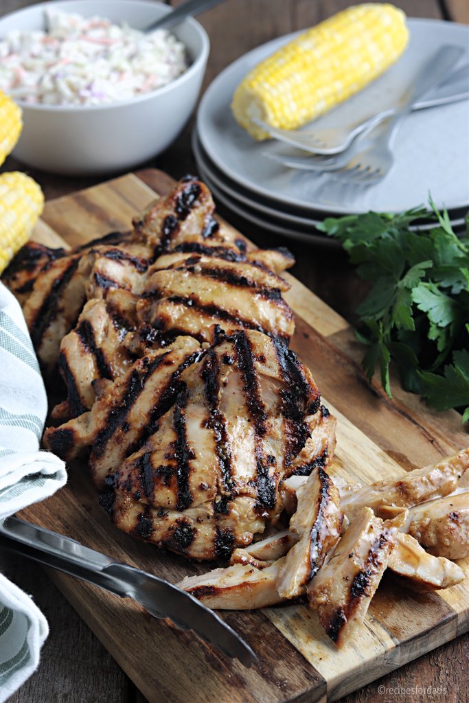 Cuisses de poulet grillées sans os, servies sur une planche à découper