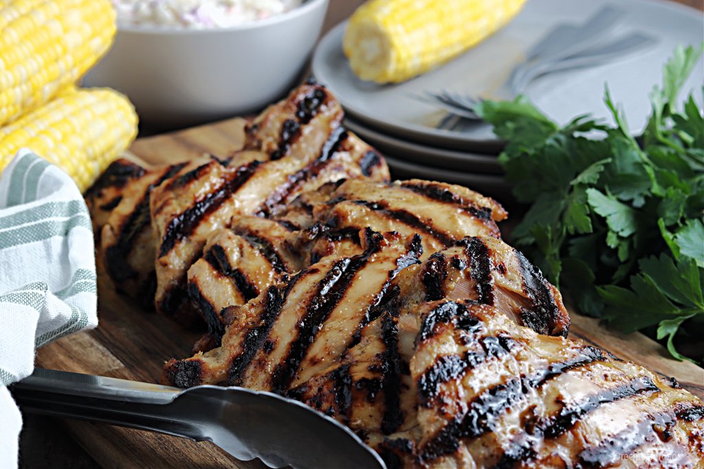 Cuisses de poulet grillées sans os, servies avec du maïs jaune et de la salade de chou